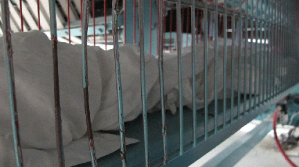 The employee’s hand was injured in an in-running nip point, when she raised the hinged grate to retrieve linen that had not been folded.