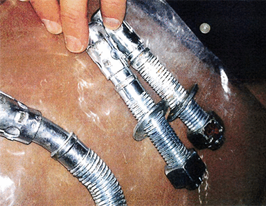 Figure 2: A view of some of the undersize anchors used to secure the capstan winch. The anchors at the upper right failed by pulling out of the concrete slab. The one at the lower left failed by bending and pulling out.